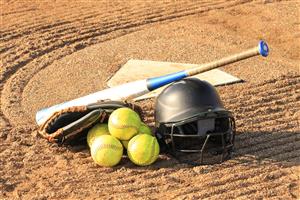 Softball bat, glove, helmet, and balls sitting atop home plate.